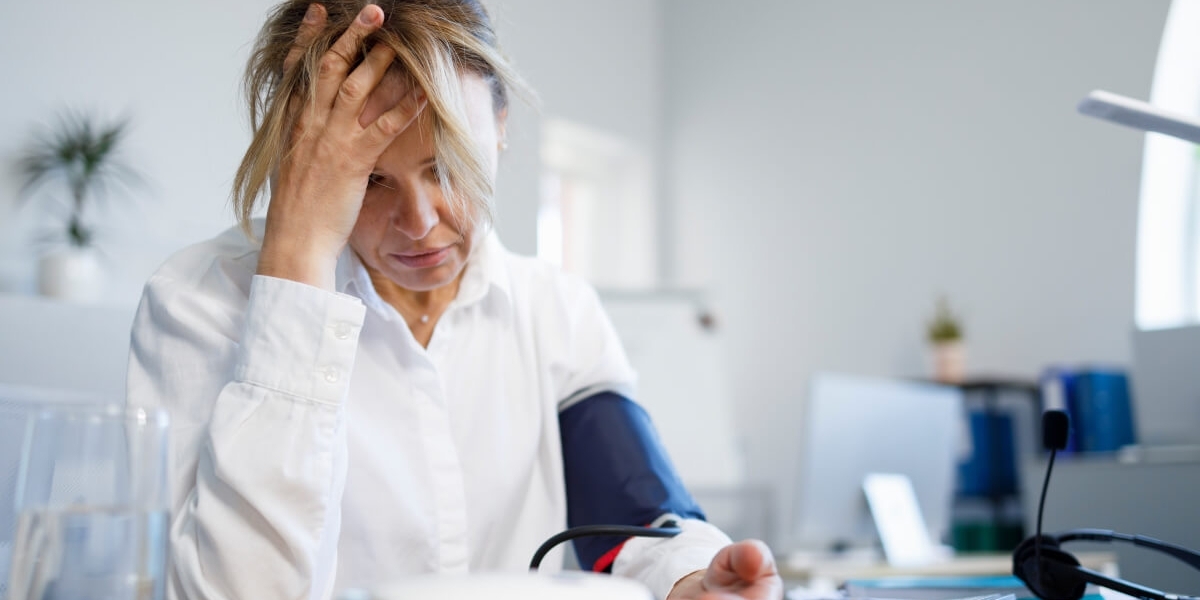Una donna in menopausa soffre di mal di testa a causa della pressione alta